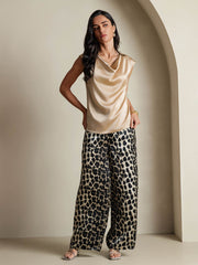 Women's champagne 19Momme silk cap sleeve cowl neck top paired with leopard print wide-leg pants.