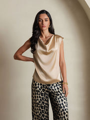 Women's 19Momme silk cap sleeve cowl neck top in champagne, paired with leopard print pants.