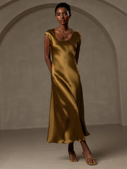 Woman in a gold mulberry silk cap sleeve round neck midi dress.
