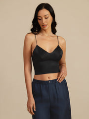 Black 19Momme mulberry silk crop top with spaghetti straps and V-neck, worn by a woman.