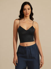 Black 19Momme mulberry silk crop top with spaghetti straps and V-neck, worn by a woman.
