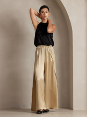 Women's fashionable flowy high-slit palazzo pants in champagne mulberry silk, paired with a black silk top.