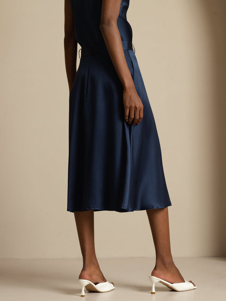 Navy mulberry silk high-waist A-line midi skirt with pockets, worn by a woman.