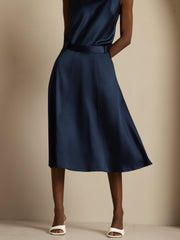 Navy 19Momme mulberry silk high-waist A-line midi skirt with pockets, worn by a woman.