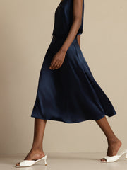 Navy blue 19Momme mulberry silk high-waist A-line midi skirt with pockets, worn by a woman.