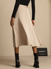 19Momme mulberry silk high-waist A-line midi skirt in champagne with pockets, worn with black top and boots.