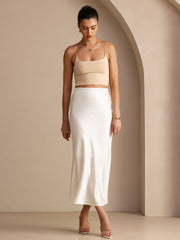 Elegant white mulberry silk high-waist maxi skirt with a subtle sheen, paired with a beige crop top.