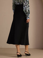 Black 19Momme silk high waist elegant maxi skirt with a subtle sheen, worn with a patterned blouse.