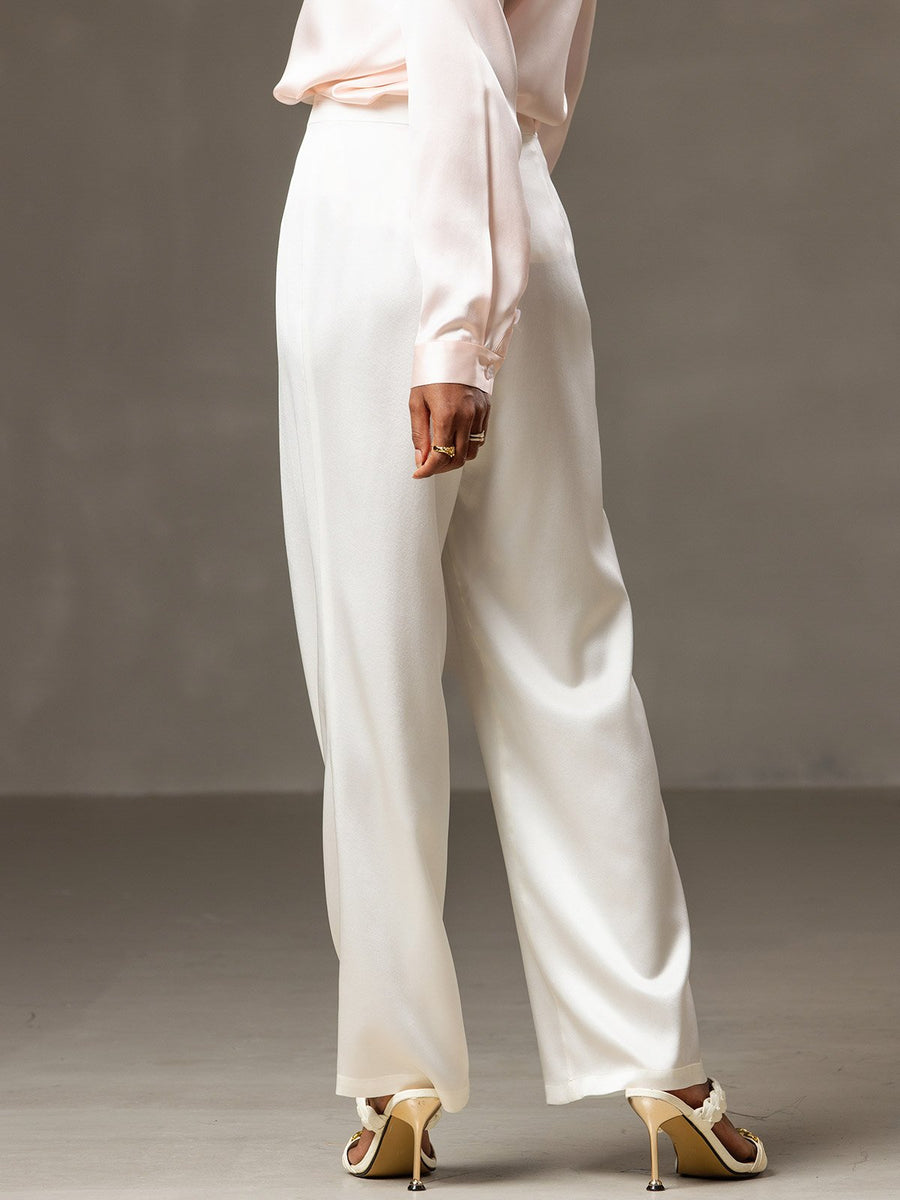 Women's white 19Momme mulberry silk high-waist wide-leg pleated pants with a light pink silk top.
