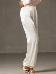 White 19Momme silk high waist wide leg pleated women's pants with gold chain sandals.