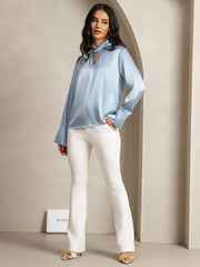 Women's light blue 19 Momme mulberry silk keyhole neck blouse with pearl buttons and white pants.