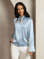 Light blue mulberry silk keyhole neck blouse with long sleeves, worn by a woman.