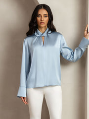 Women's light blue mulberry silk keyhole neck blouse with pearl buttons and long cuffed sleeves.