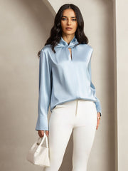 Grayish blue 19Momme mulberry silk keyhole neck blouse with pearl buttons, worn by a woman.