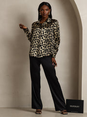 Women's 19Momme mulberry silk leopard print long sleeve lapel collar shirt with black pants.