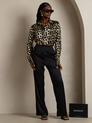 Women's 19Momme mulberry silk leopard print long sleeve lapel collar shirt with black pants.