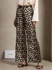 Women's 19Momme mulberry silk leopard print straight leg pants with side pockets, paired with a cream blouse.