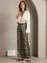 Women's 19 Momme mulberry silk leopard print straight leg pants with side pockets, paired with a cream silk top.