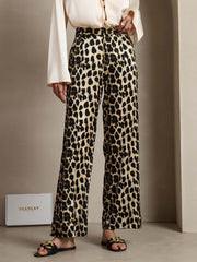 Women's 19 Momme mulberry silk leopard print straight leg pants with side pockets.