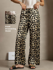 Women's 19 Momme mulberry silk leopard print wide leg pants with a front drawstring waist and side pockets.