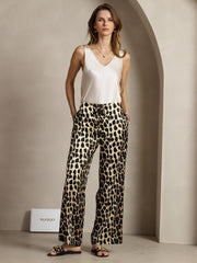 Woman in 19Momme mulberry silk leopard print wide leg pants with side pockets and a white silk top.