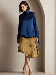 Women's navy 19Momme mulberry silk long sleeve high neck bow tie blouse with a gold skirt.