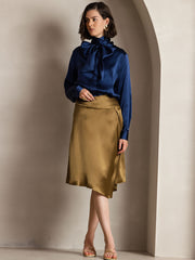 Women's navy mulberry silk long sleeve high neck bow tie blouse with a gold satin skirt.