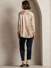 Women's 19Momme mulberry silk long sleeve lapel collar shirt in champagne, paired with black pants.