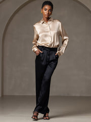 Women's 19 Momme mulberry silk long sleeve lapel collar shirt in champagne, paired with black satin pants.