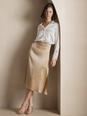 Woman wearing a white 19Momme mulberry silk long sleeve lapel collar shirt and a beige silk midi skirt.
