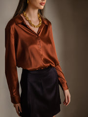 Women's caramel 19Momme silk long sleeve lapel collar shirt with button-up design, paired with a black skirt.