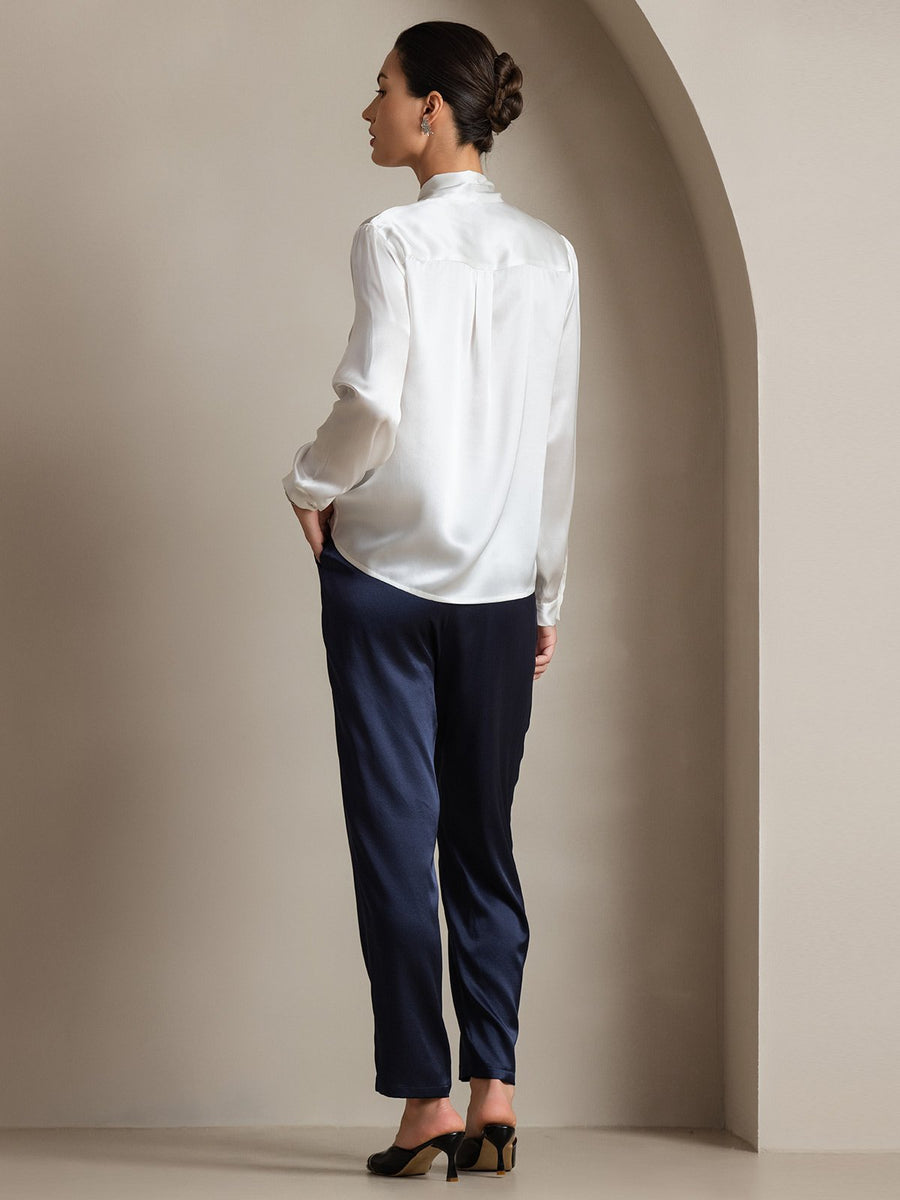 White 19Momme mulberry silk long sleeve tie neck blouse with navy pants.