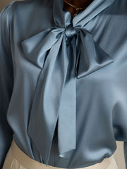 Light blue 19Momme mulberry silk long sleeve tie-neck blouse.