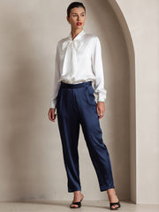 White 19Momme mulberry silk long sleeve tie neck blouse paired with navy trousers.