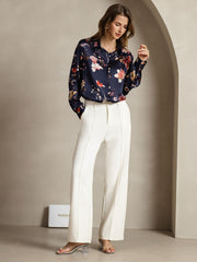 Women's 19Momme mulberry silk navy floral print long sleeve lapel collar shirt with white pants.