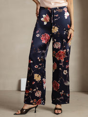 Women's navy mulberry silk wide-leg pants with a vibrant floral print and side pockets.