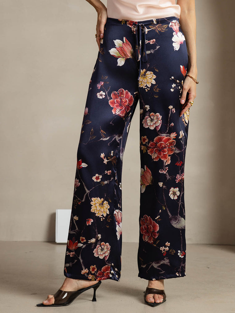 Women's navy mulberry silk wide-leg pants with a vibrant floral print and side pockets.