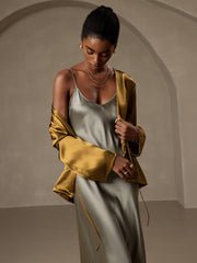 Women's relaxed long sleeve tie-front mulberry silk cardigan in gold over a gray silk slip dress.