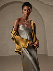 Woman in a relaxed 19 Momme mulberry silk tie-front cardigan in bronze over a sage silk slip dress.