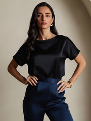 Woman in a black 19Momme mulberry silk short sleeve boat neck t-shirt and navy silk pants.