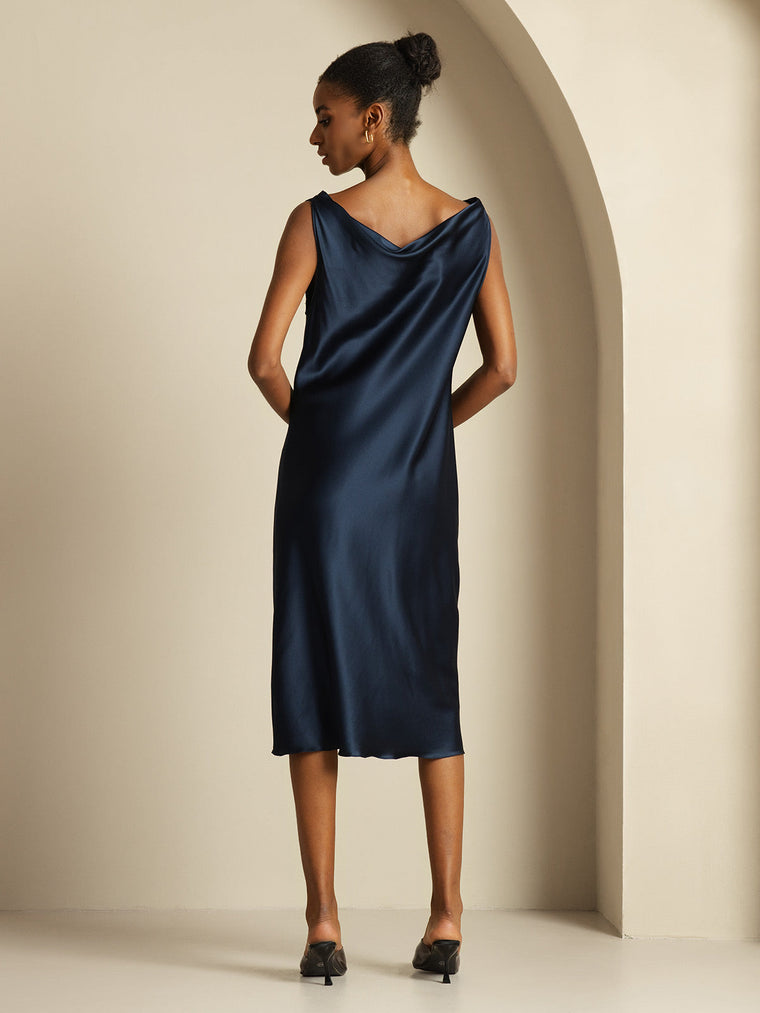 Navy mulberry silk sleeveless cowl neck knee dress on a woman.