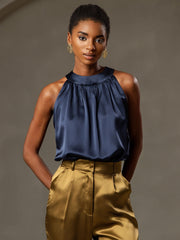 Women's navy mulberry silk sleeveless halter neck top with gold pants.