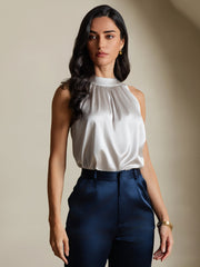 Light gray 19Momme mulberry silk sleeveless halter neck women's top with a high collar, paired with navy pants.