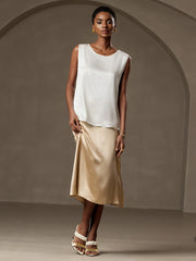 White 19Momme mulberry silk sleeveless round neck tank top with a gold silk skirt.