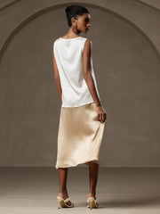 Women's white 19 Momme mulberry silk sleeveless round neck tank top with a gold silk skirt.