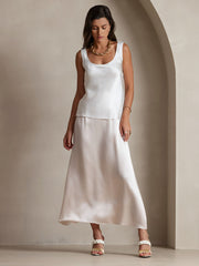 Woman in a white 19Momme mulberry silk sleeveless U-neck tank top and matching skirt.