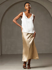White mulberry silk sleeveless V-neck tank top with V-back design, paired with a gold silk skirt.