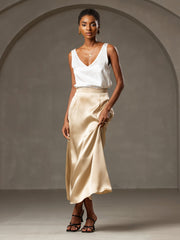 Woman wearing a white 19Momme mulberry silk sleeveless V-neck tank top and a champagne silk maxi skirt.