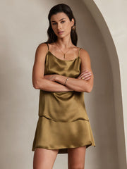 Woman wearing a gold mulberry silk spaghetti strap camisole and matching silk shorts.