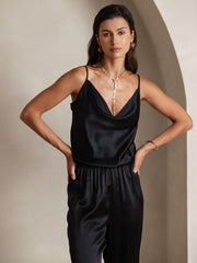 Woman wearing a black mulberry silk spaghetti strap cowl neck camisole top and matching silk pants.